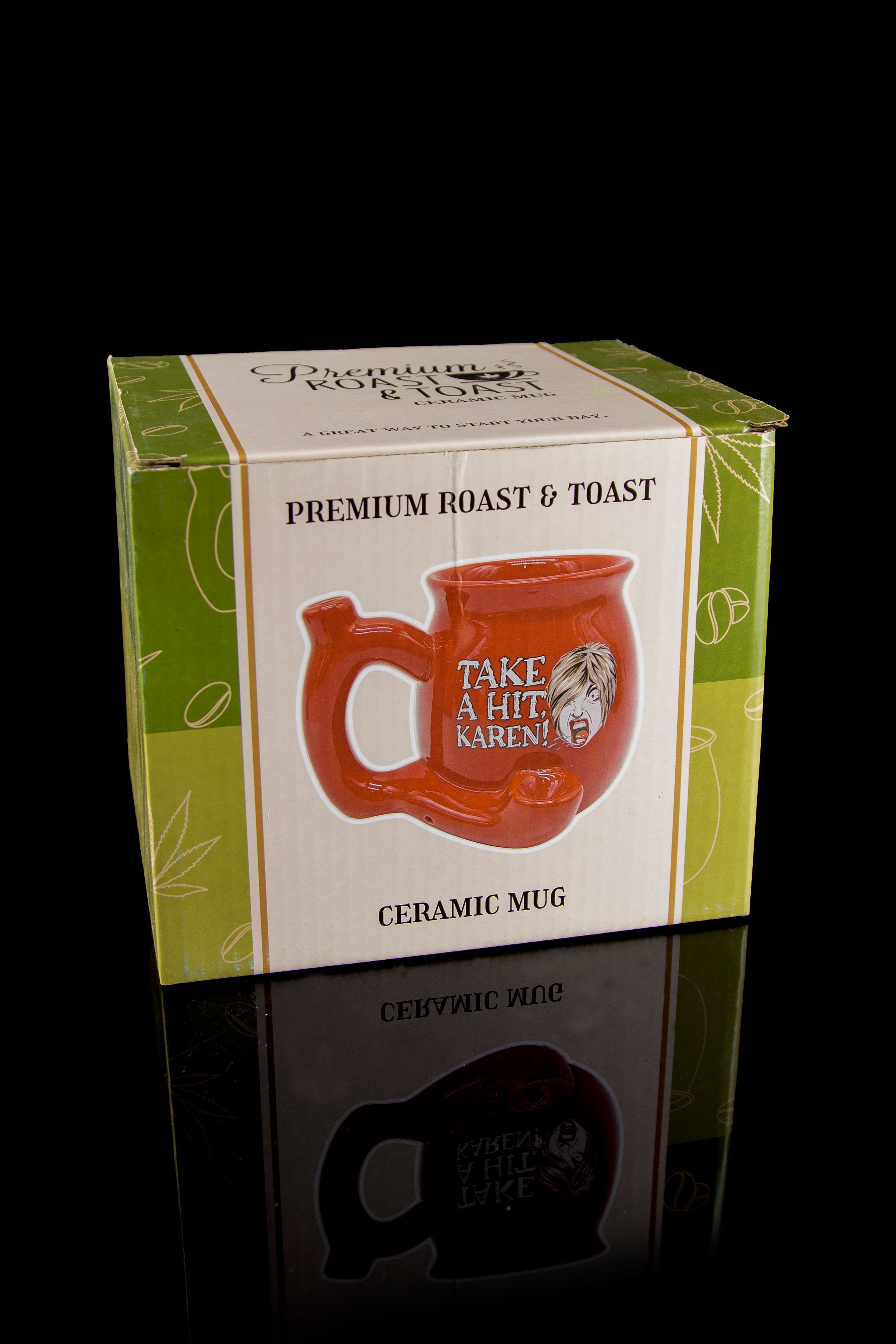 Product packaging for a novelty ceramic mug with a cannabis leaf design and the phrase "Take a hit, Karen!" reflecting on a glossy surface.