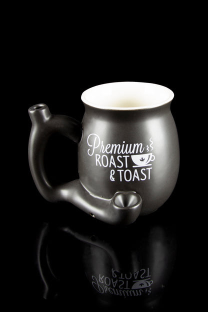 Black ceramic cannabis water pipe shaped like a teapot with “Premium Roast & Toast” script, reflecting on a dark surface.