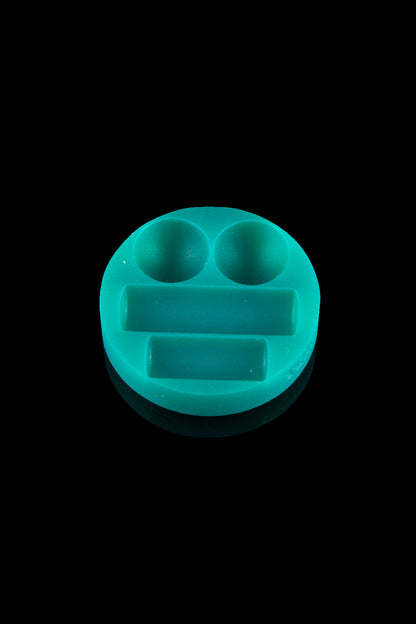 Teal silicone concentrate container with two bowls and a dab tool resting space, isolated on black.