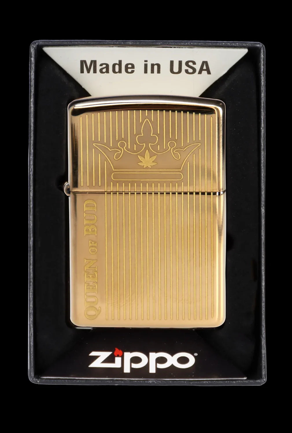 Gold Zippo lighter with a cannabis leaf crown design and “Queen of Bud” engraved on the side, displayed in a black plastic case.