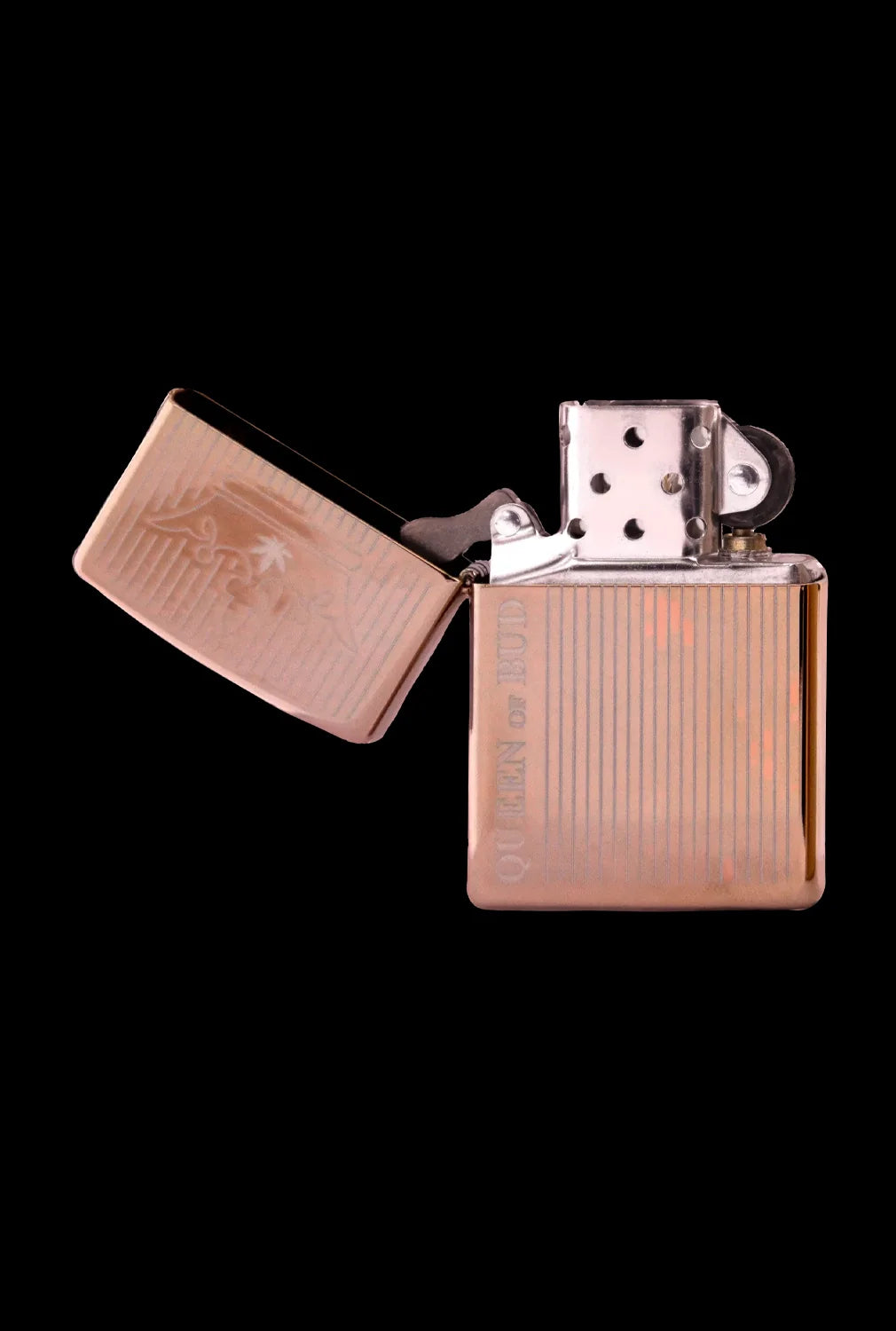 Open gold-toned lighter with engraved vertical lines on a black background.