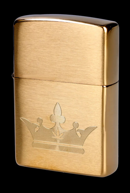 Gold Zippo lighter with a cannabis leaf design engraved on the front.