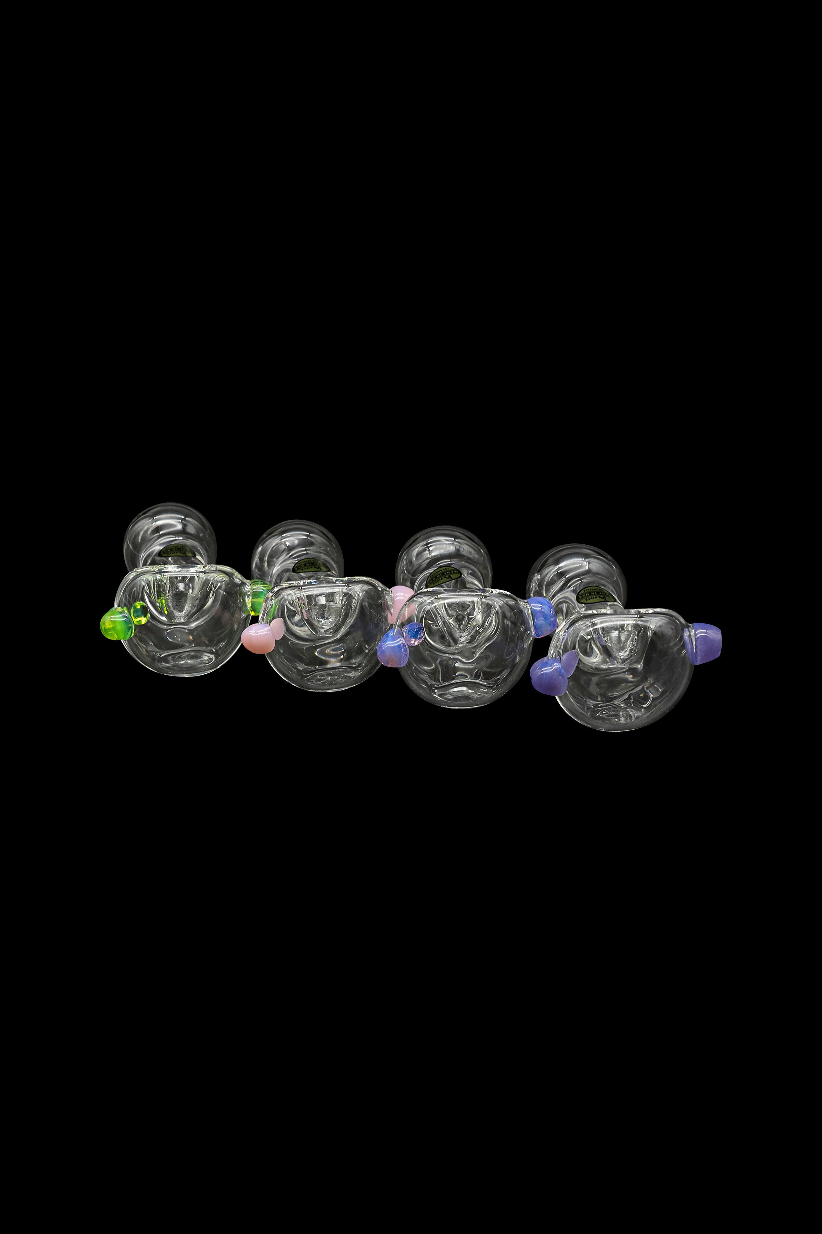 A row of colorful glass cannabis bubblers against a black background.