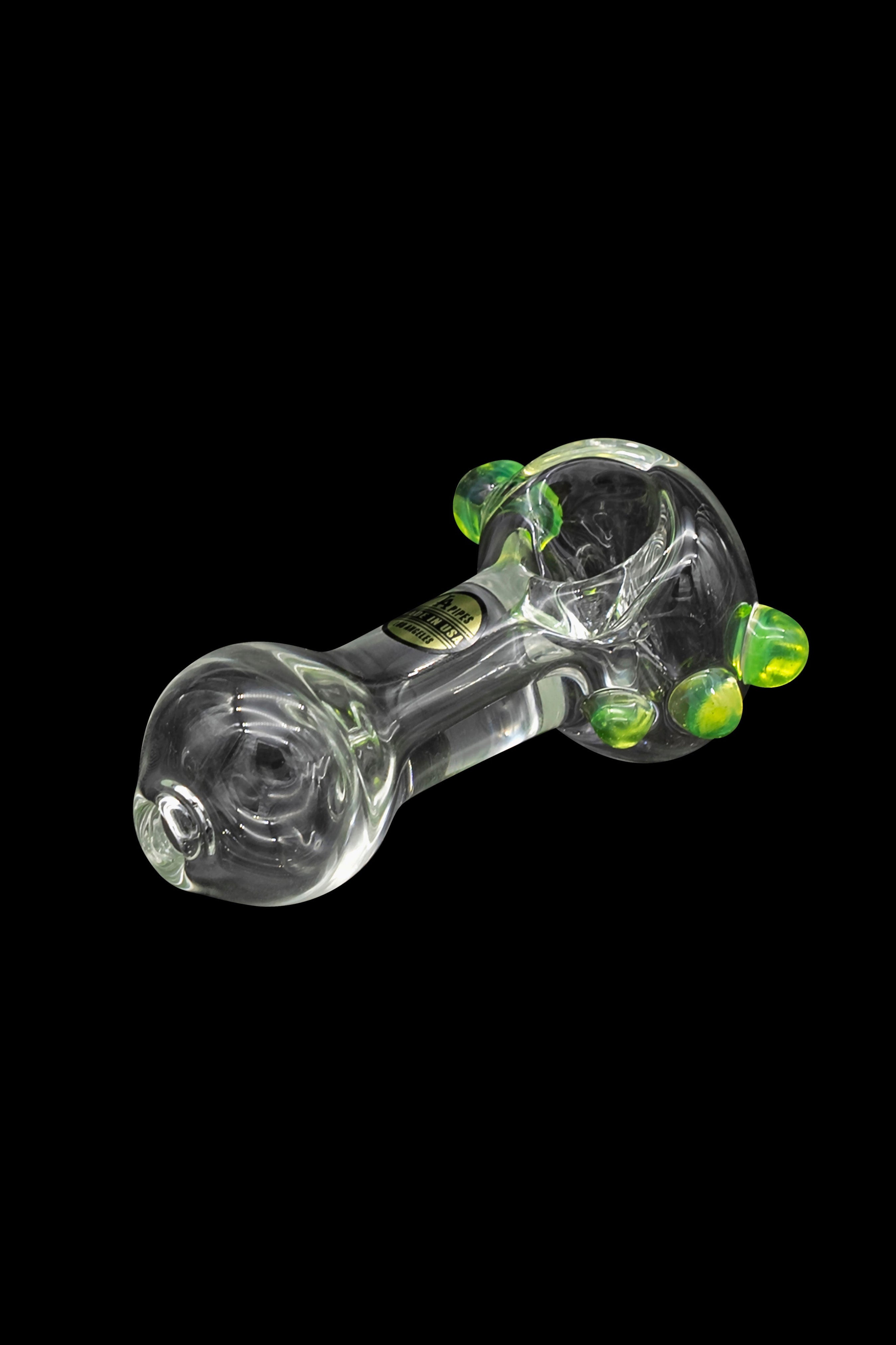 Glass cannabis pipe with green accents, isolated on a black background.