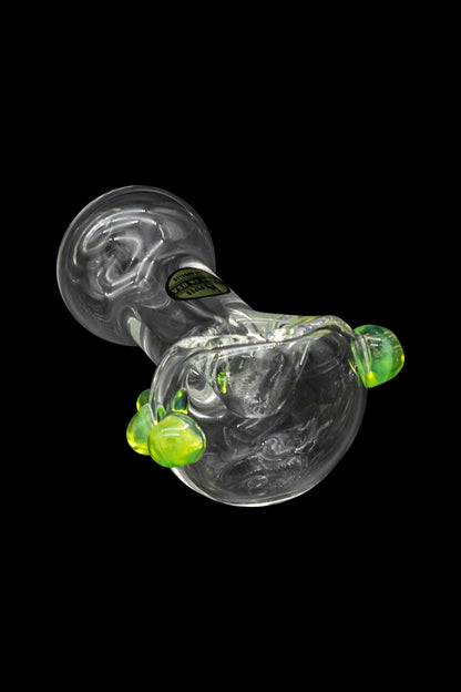 Glass cannabis water pipe with green accents against a black background.