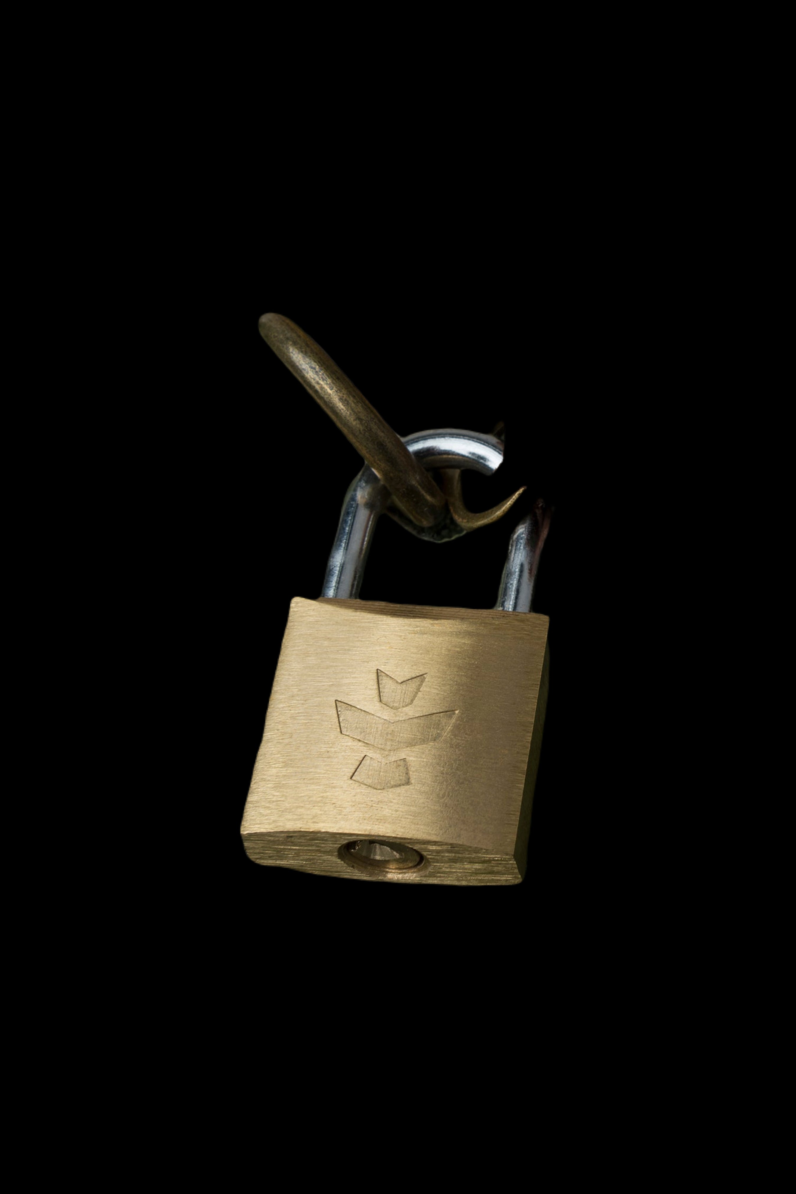 A brass padlock with a cannabis leaf emblem, secured to a metal shackle against a black background.
