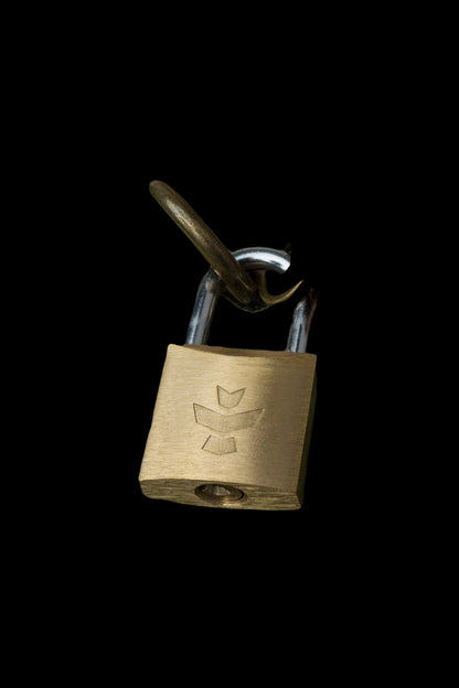 A brass padlock with a cannabis leaf emblem, secured to a metal shackle against a black background.
