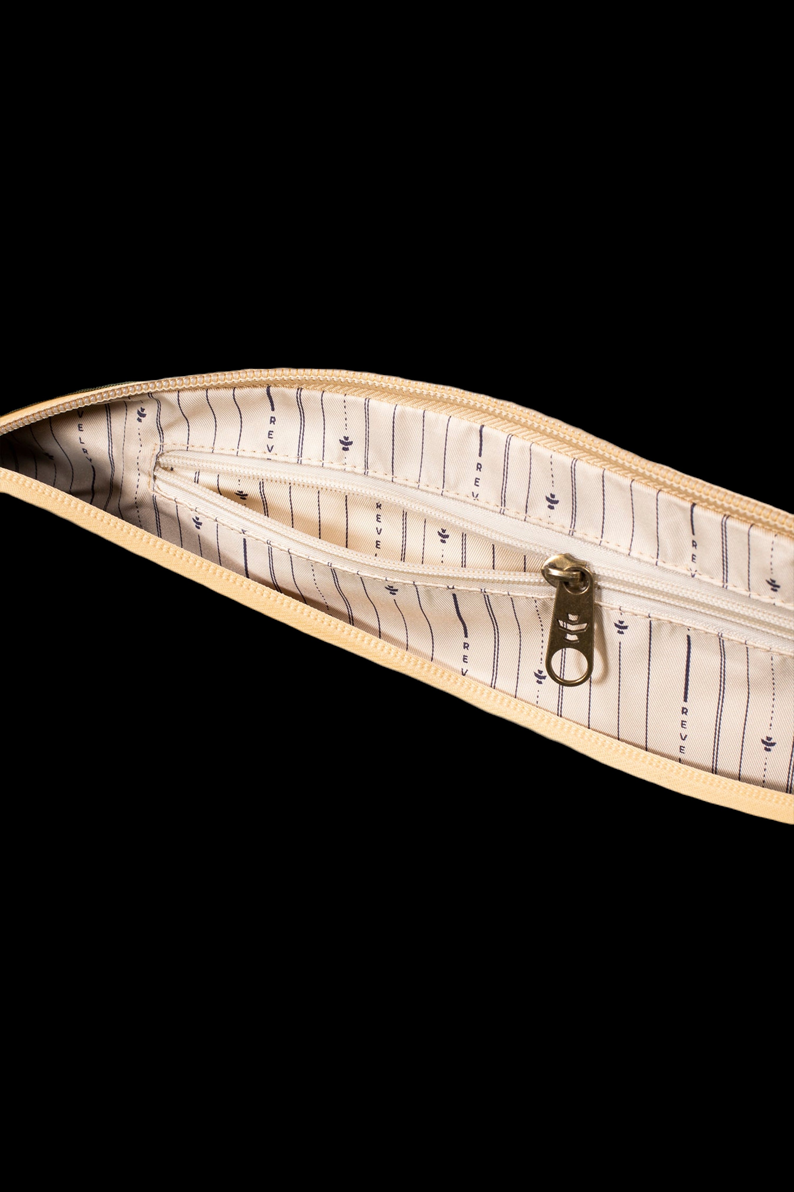 Tan cannabis accessory case with a patterned lining and gold zipper partially open.