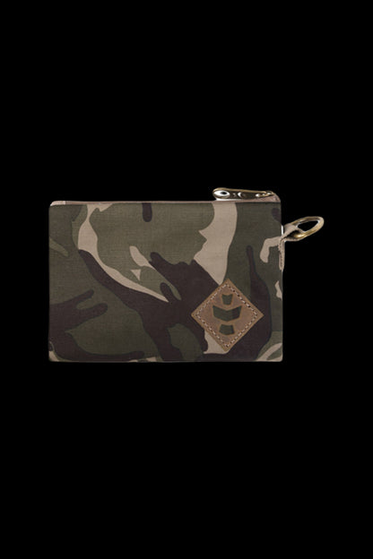 Close-up front view of the camo Revelry Supply Smell Proof Zippered Small Stash Bag - The Mini Broker showing the top zipper, keyring loop, and stitched leather patch.