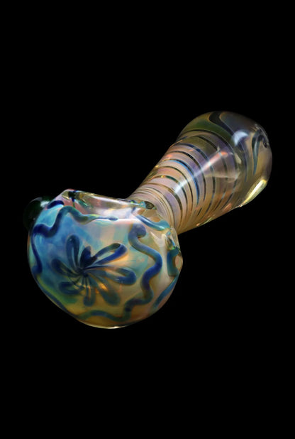 Iridescent glass pipe with floral detailing against a black background.