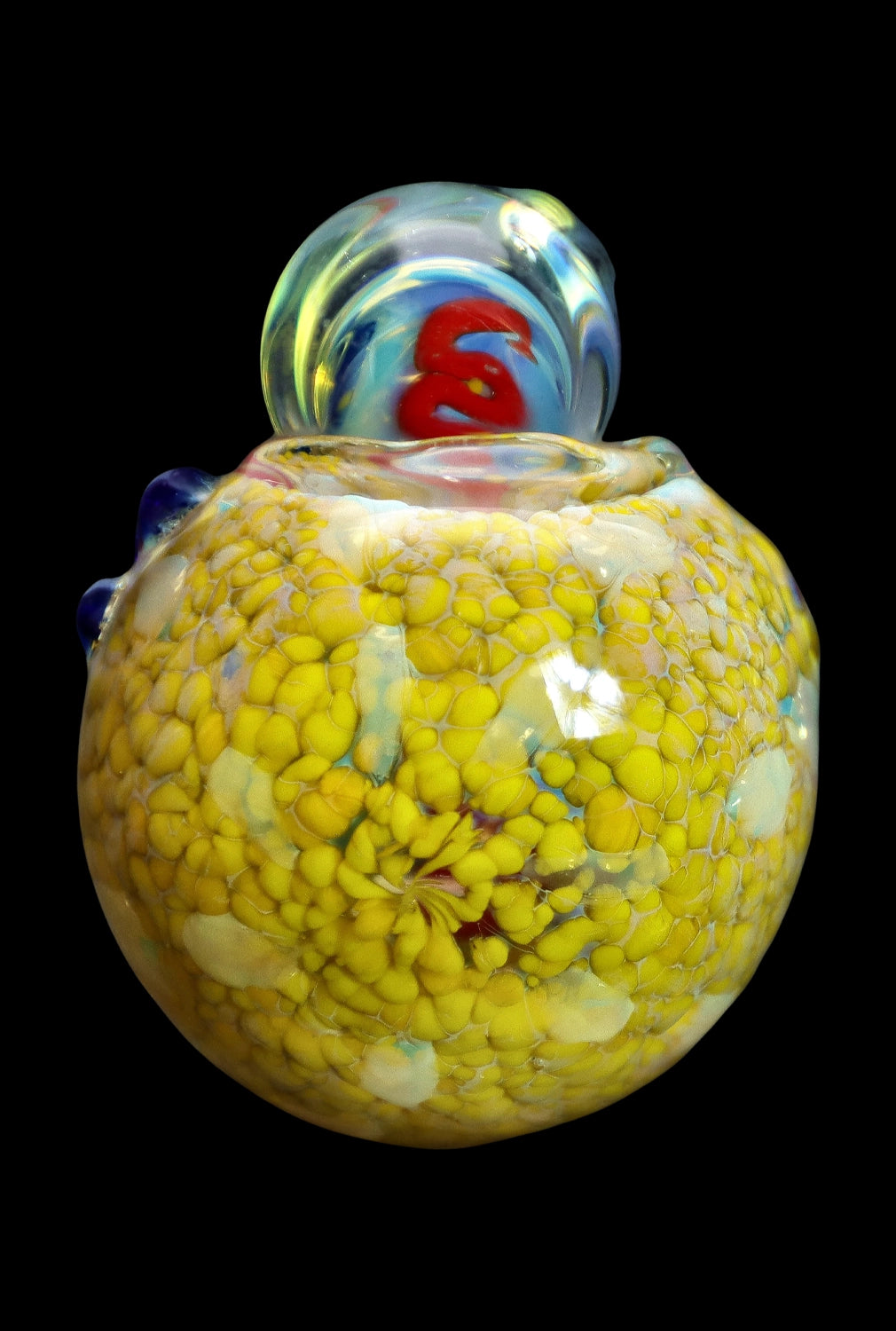 Yellow and red speckled glass cannabis water pipe against a black background.