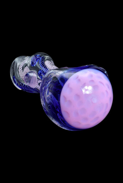 Purple glass cannabis pipe against a black background.