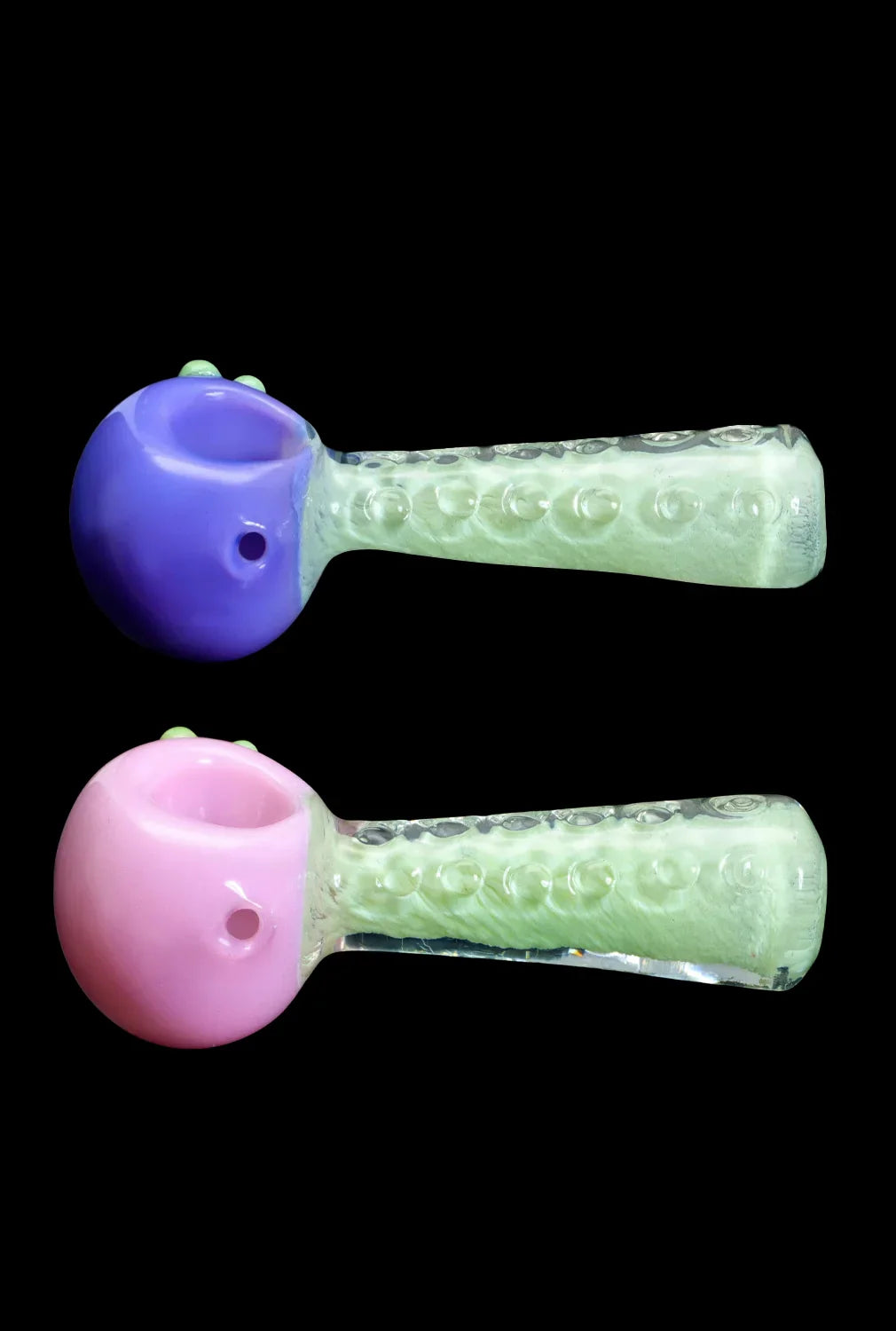 Two glass pipes with colorful bowls and textured green stems against a black background.