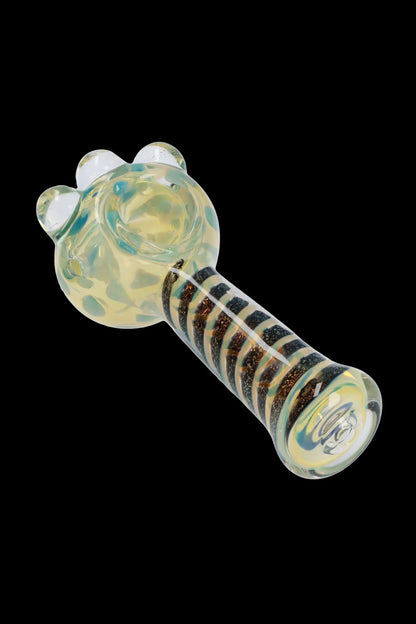 A close-up, angled view of the Dicro Spoon Pipe - 4.5 in., showcasing its smooth glass form and unique dichroic finish.