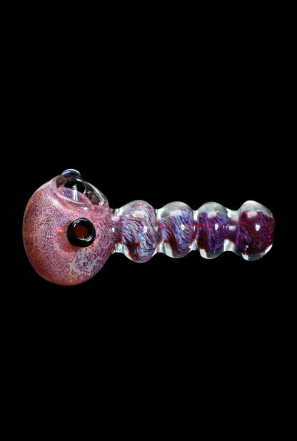 Colorful glass pipe with a speckled red bowl and purple, swirled stem, isolated on a black background.