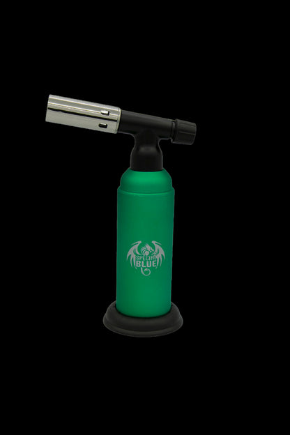 Green butane torch with dragon logo, used for dabbing cannabis concentrates.