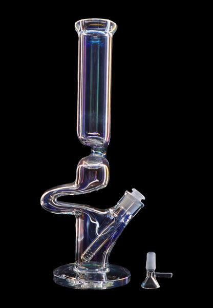 Clear glass water pipe (bong) with a complex, serpentine shape, illuminated with colorful lighting, and a small glass bowl beside it on a black background.