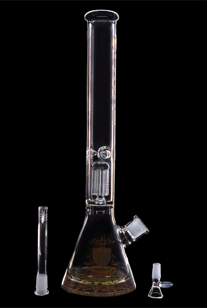 A tall, intricately designed glass water pipe (bong) with a wide base and detailed etching, accompanied by a glass downstem and bowl, isolated on a black background.