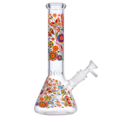 Angled view of the Smoke Cartel Skull Beaker Bong - 10 in. showing its clear glass beaker and neck decorated with colorful floral and butterfly motifs.