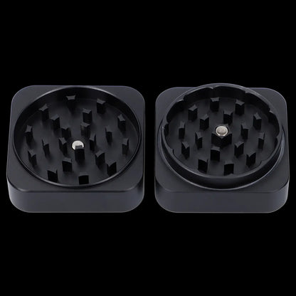 Two black cannabis grinders with visible metal teeth, isolated on a black background.