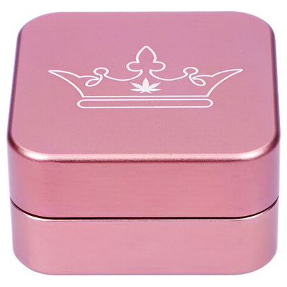 Pink metal grinder with a white cannabis leaf crown design.