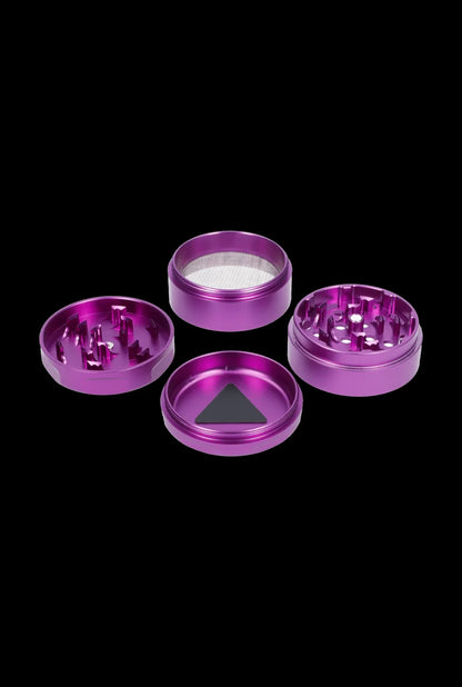 Purple four-piece cannabis grinder disassembled, showing each component against a black background."