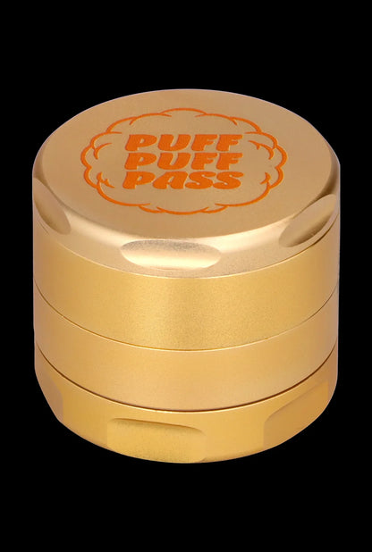 Gold cannabis grinder with “PUFF PUFF PASS” engraved on the lid.