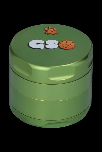 Green cannabis grinder with “GSØ” logo and leaf illustration.