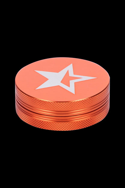 Orange metal grinder with a white star emblem.