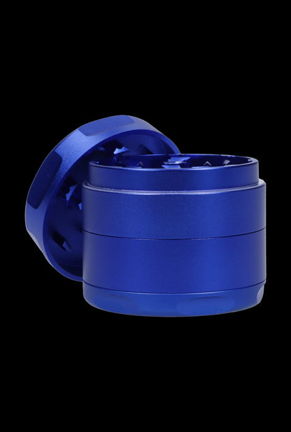 Angled close-up of the blue Famous Design-Privilege Aluminum 3 Stage Grinder-Blue against a black background, showing its textured sides and exposed toothed interior.