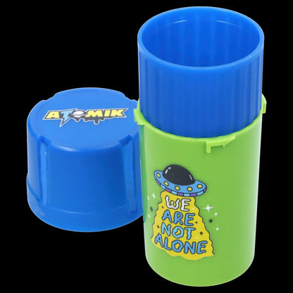Bright green and blue cannabis container with alien-themed graphics and the text “We Are Not Alone.”