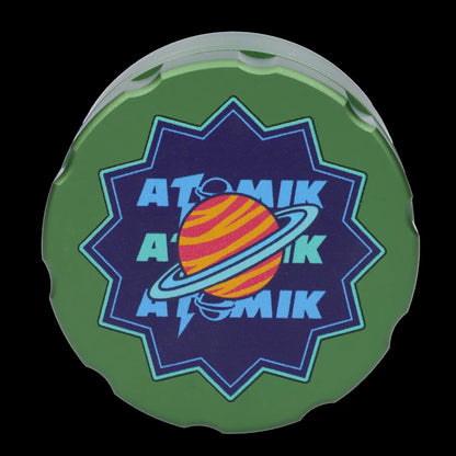 Green silicone container lid with a vibrant cosmic design featuring the brand name “ATOMIK” and a planet with rings.