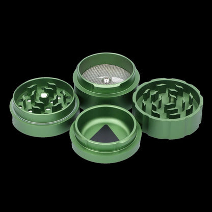 Green four-piece cannabis grinder with visible grinding teeth and collection chamber.