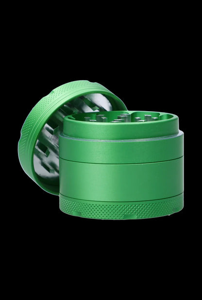Close-up front angle of the green Cabana Cannabis Co. 3-Stage Grinder Parasol Green with its lid tilted back to reveal metal teeth and textured grip against a black background