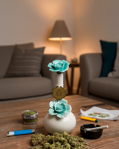 Centered front view of the My Bud Vase Bong - Rosette in mauve-toned teal, a small round vase with two floral rosettes on a living room coffee table.