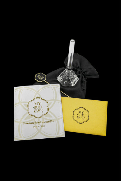 Elegant glass cannabis water pipe ("bud vase") displayed with its branded packaging, featuring a gold logo and text reading "Smoking Made Beautiful - Use & Care".