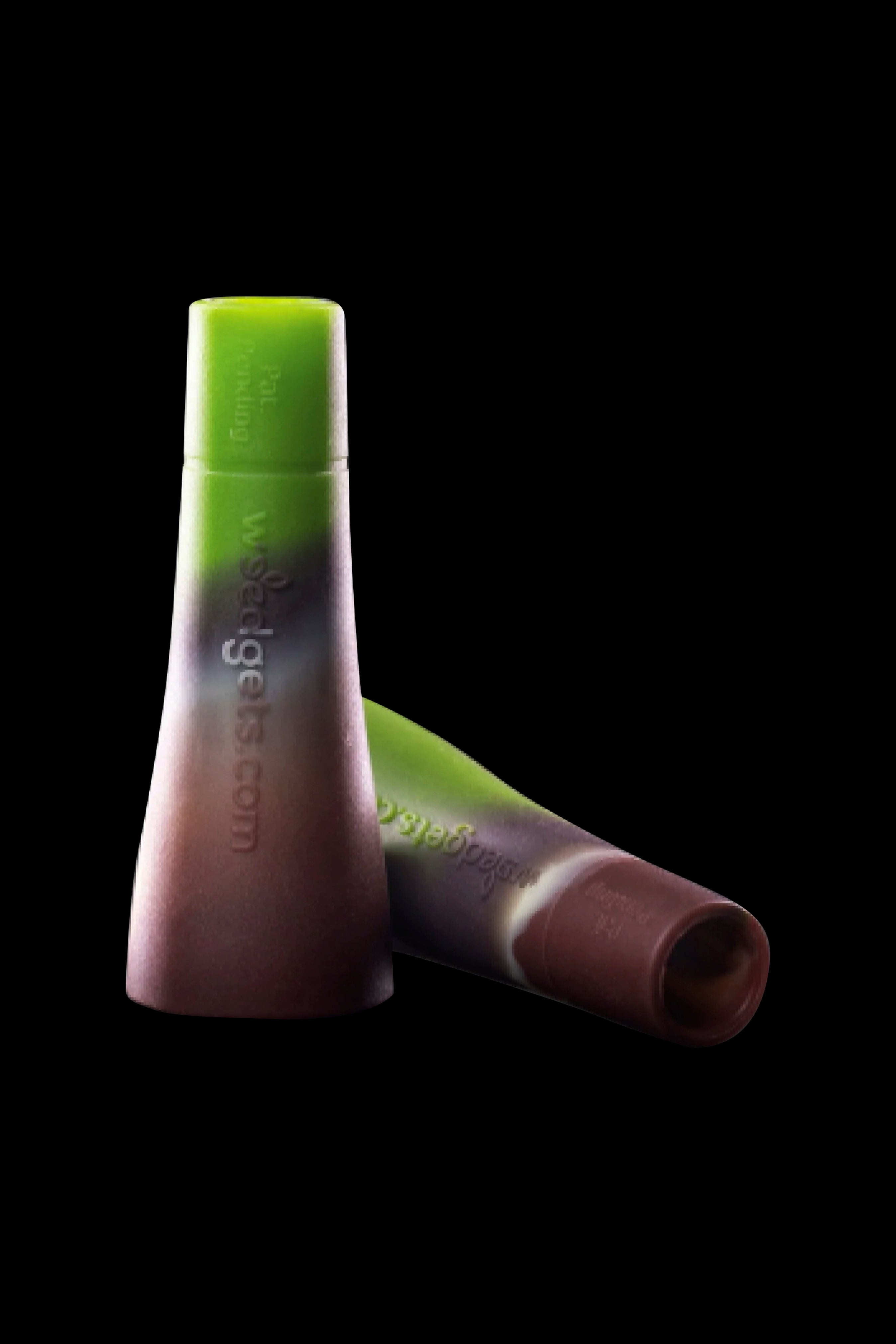 Two green silicone dab tools with “Waxology.com” printed on the side, against a black background.