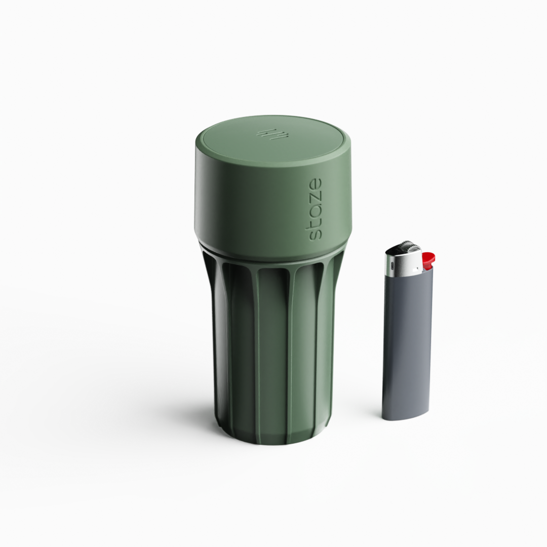 Centered three-quarter view of the Marsh-colored STAZE PRESERVE showing its ribbed cylindrical body and embossed logo beside a slim lighter on white background