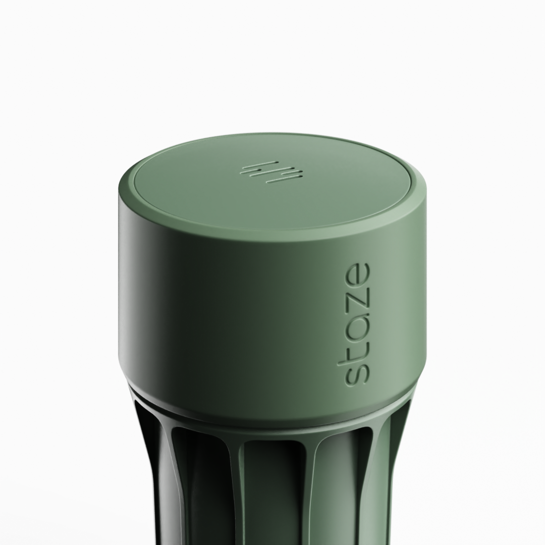 Close-up angled view of the Slate STAZE PRESERVE showing the matte green cylindrical cap with embossed "staze" lettering and ribbed body beneath.