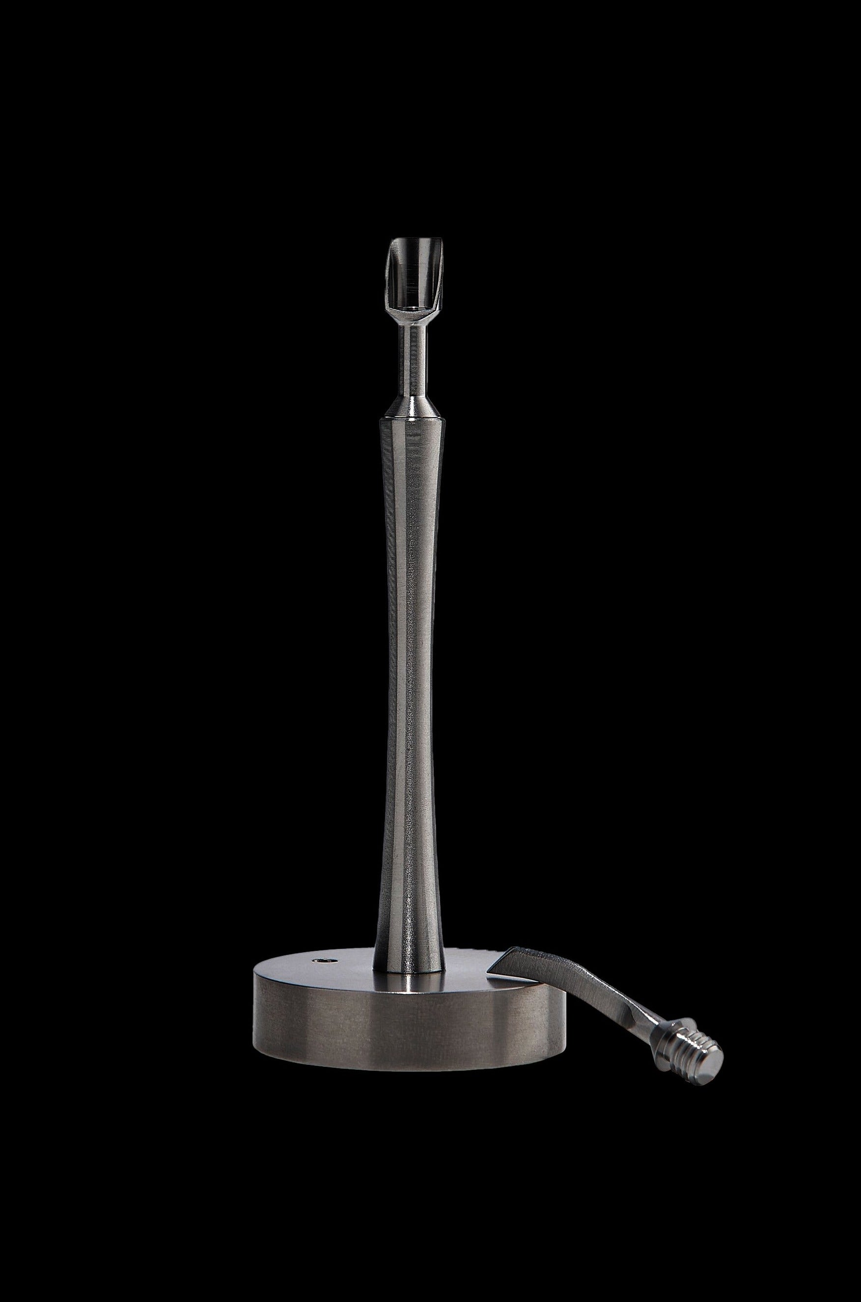 Sleek, metallic dab tool with a circular base, isolated on a black background.