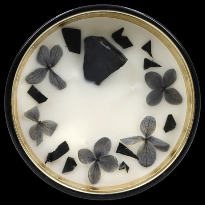 Overhead view of a white ashtray with cannabis flower pieces and stems arranged around the inside.