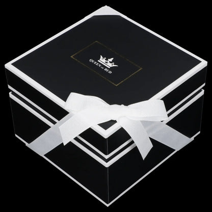 Black gift box with white ribbon and “Queen of Bud” logo, likely containing cannabis accessories.