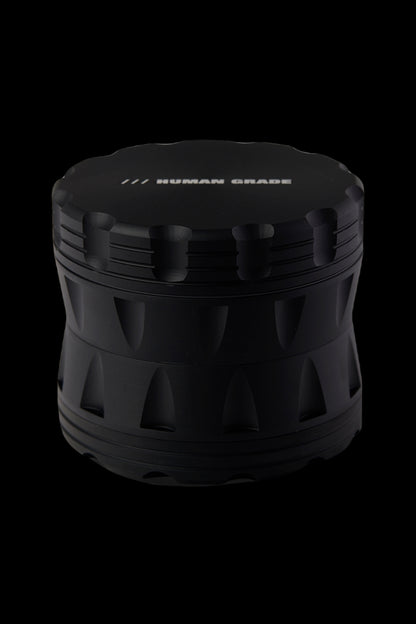 Black cannabis grinder with "HUMAN GRADE" text on top.