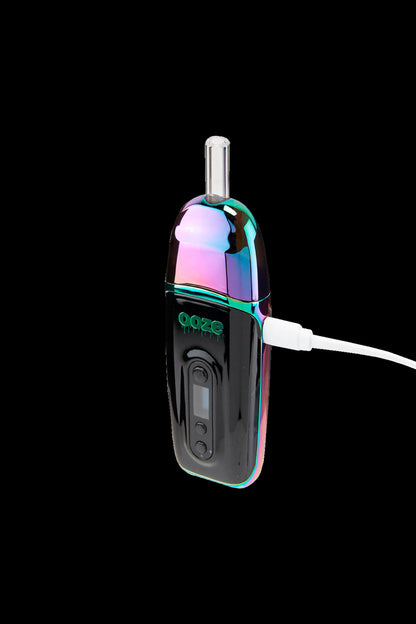 Iridescent cannabis oil vape pen plugged into a USB charging cable against a black background.