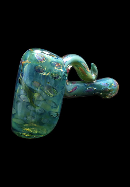 Angled close-up of the Smoke Cartel Gold Fume Bubble Trap Hammer Bubbler - 6 in., showing its iridescent green-blue glass with raised bubble textures against a black background