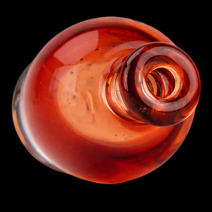 Top-down close-up of the Empire Glassworks Puffco Pivot Glass Mouthpiece - Transparent Red showing its glossy red glass rim and rounded interior against a black background