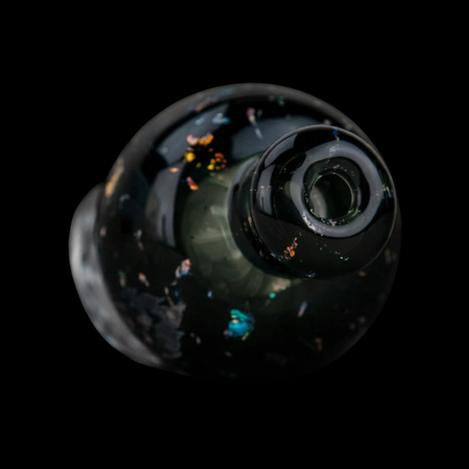 Top-down close-up of the black, speckled Empire Glassworks Puffco Pivot Glass Mouthpiece - Black Nebula showing the rounded opening and scattered iridescent flecks.