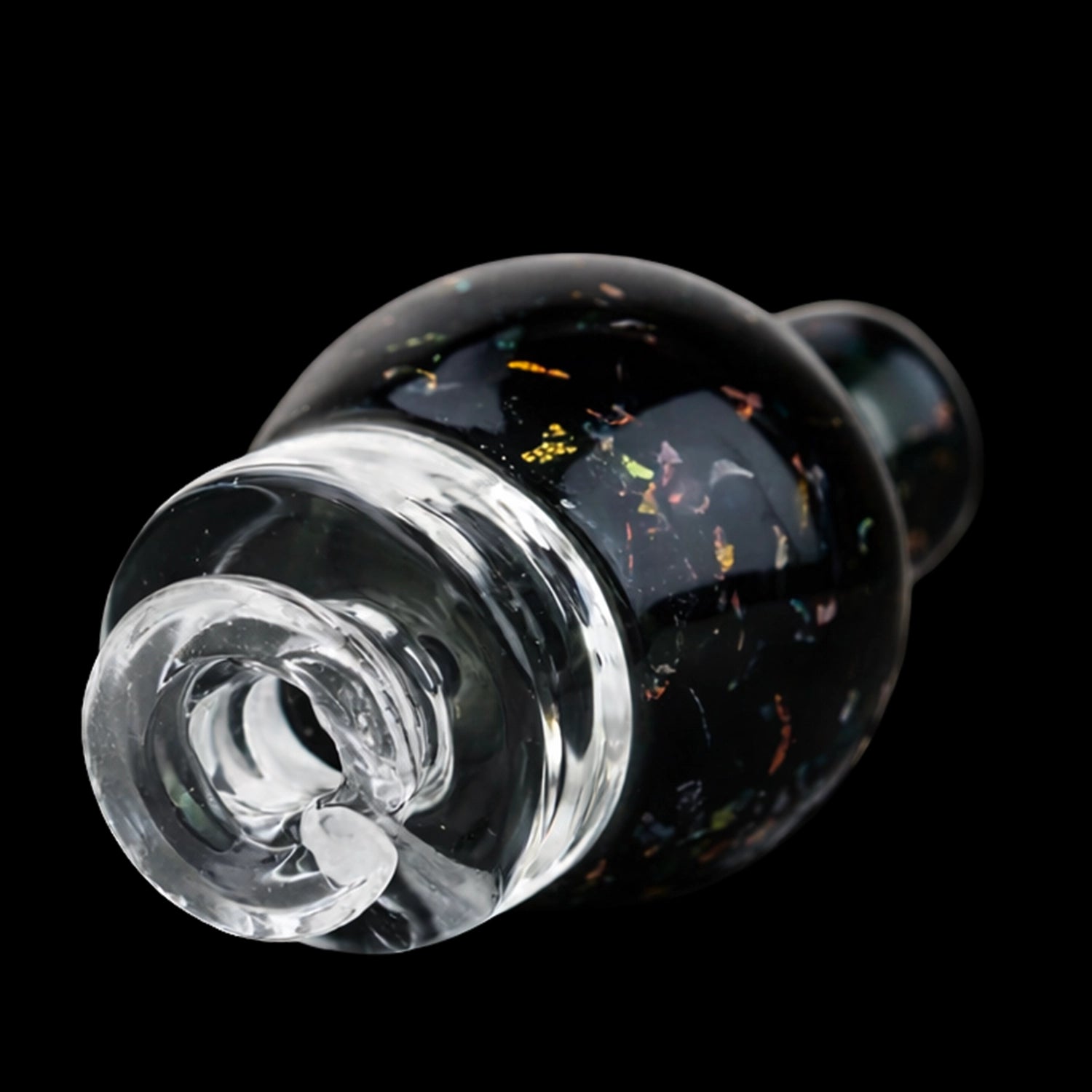 Angled close-up of the Empire Glassworks Puffco Pivot Glass Mouthpiece - Black Nebula showing its clear spiral tip and dark nebula-speckled glass body against a black background