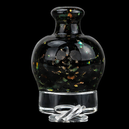 Close-up front view of the Empire Glassworks Puffco Pivot Glass Mouthpiece - Black Nebula showing a rounded black glass bulb with green and gold flecks on a clear glass base.
