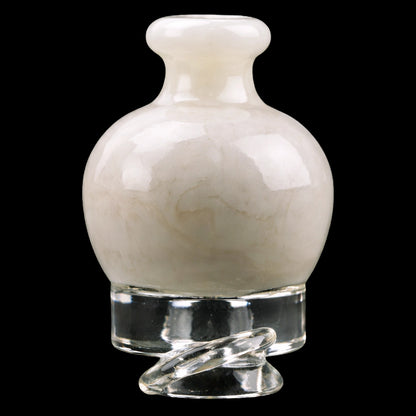 Close-up front view of the Empire Glassworks Puffco Pivot Glass Mouthpiece - Glow in the Dark showing its rounded, pale glowing bulb and clear twisted glass base against a black background.